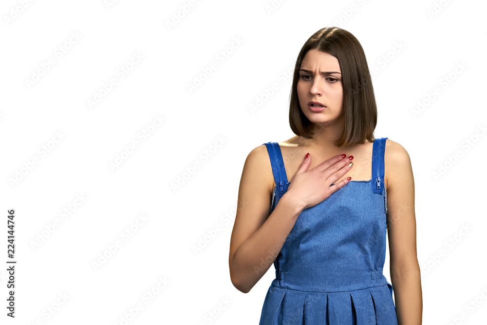 Young pretty woman feeling pain in chest. Portrait of young beautiful female student looking worried and sick over white background, copy space. Young pretty woman feeling pain in chest. Portrait of young beautiful female student looking worried and sick over white background, copy space.