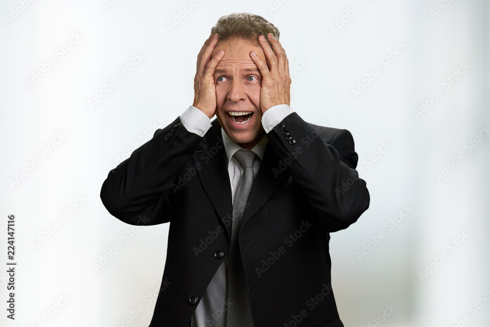 Portrait of frustrated middle-aged businessman. Man in formal wear holding hands on head in frustration. Confused middle-aged entrepreneur. Portrait of frustrated middle-aged businessman. Man in formal wear holding hands on head in frustration. Confused middle-aged entrepreneur.