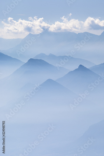 Blue layers of mountain ridges in the french alps with clouds