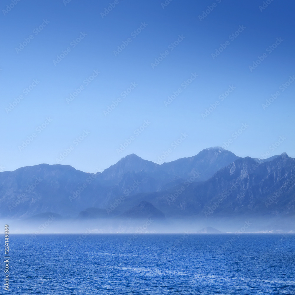 seascape with mountains over clear blue sky seascape with mountains over clear blue sky