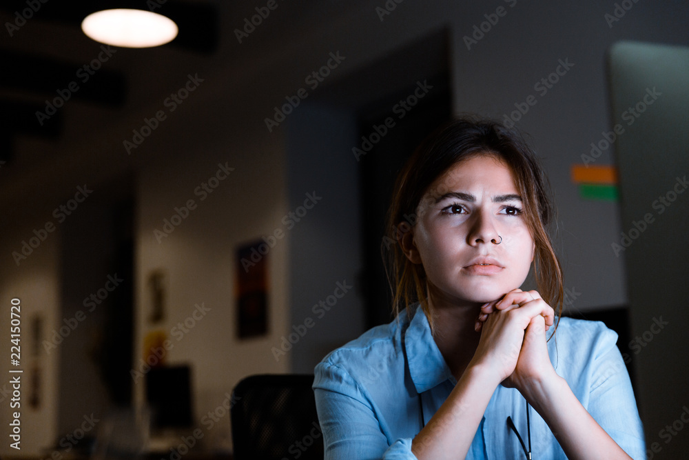 Young woman graphic designer using pc computer working at night in office. Young woman graphic designer using pc computer working at night in office.