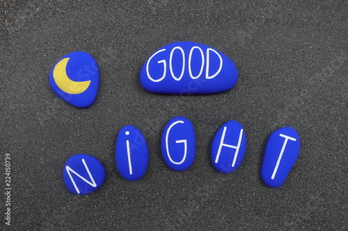 Good night text and design with colored and carved stones over black volcanic sand
