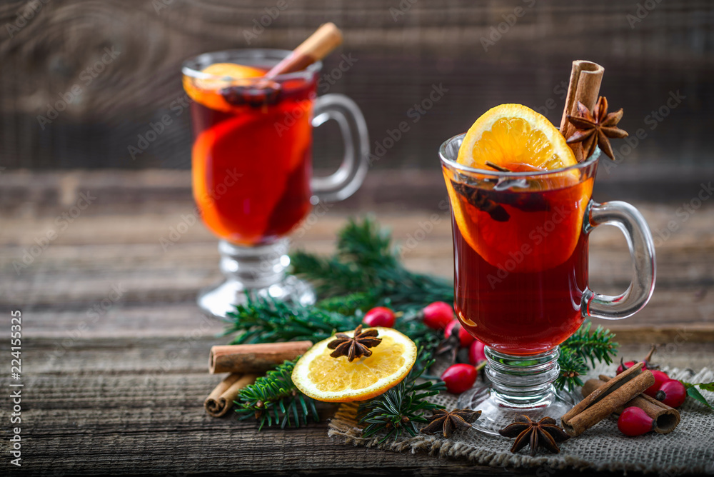 Hot wine with cinnamon, orange and anise or glass of tea, winter drink with aromatic spices