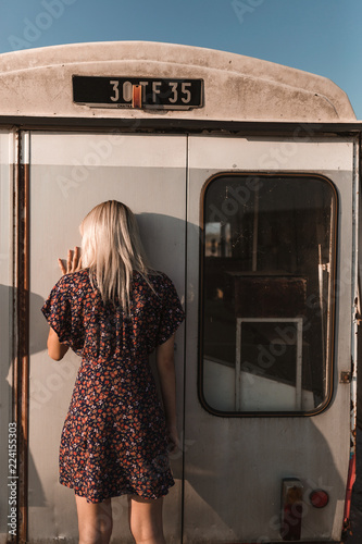 Rear view of woman leaning on old van