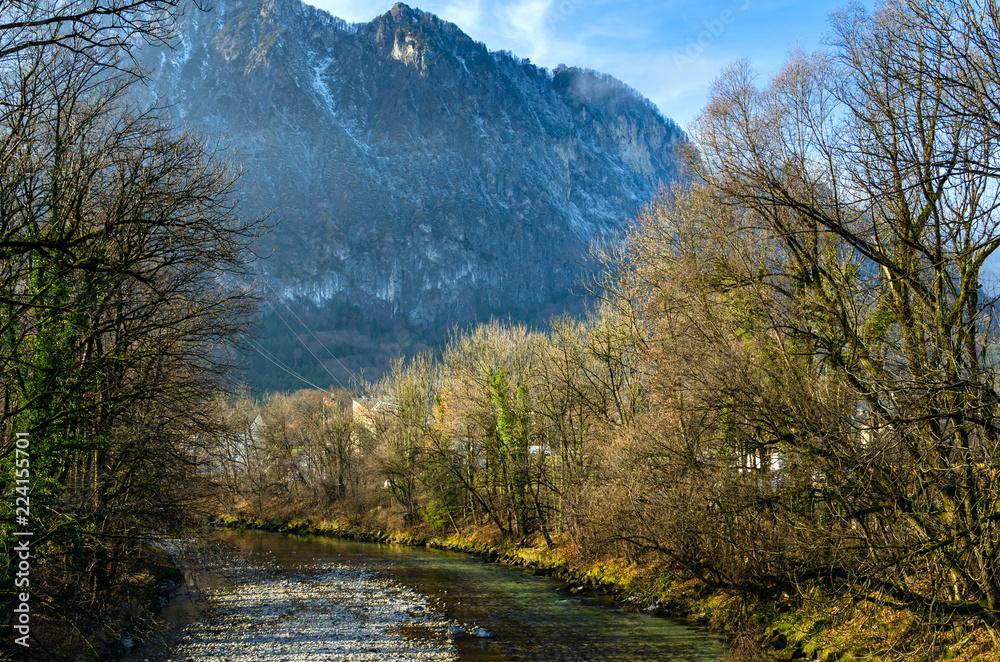 River with Wooden Banks in a Mountain Landscape on a Sunny Winter Day