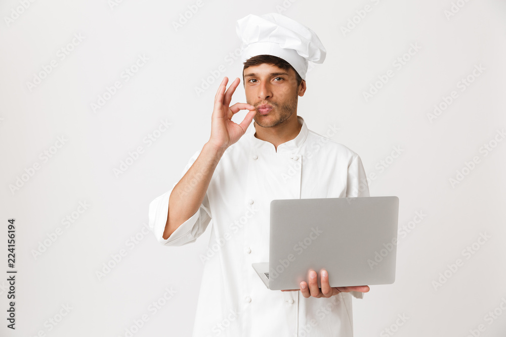 Chef man isolated over white wall background using laptop computer. Chef man isolated over white wall background using laptop computer.