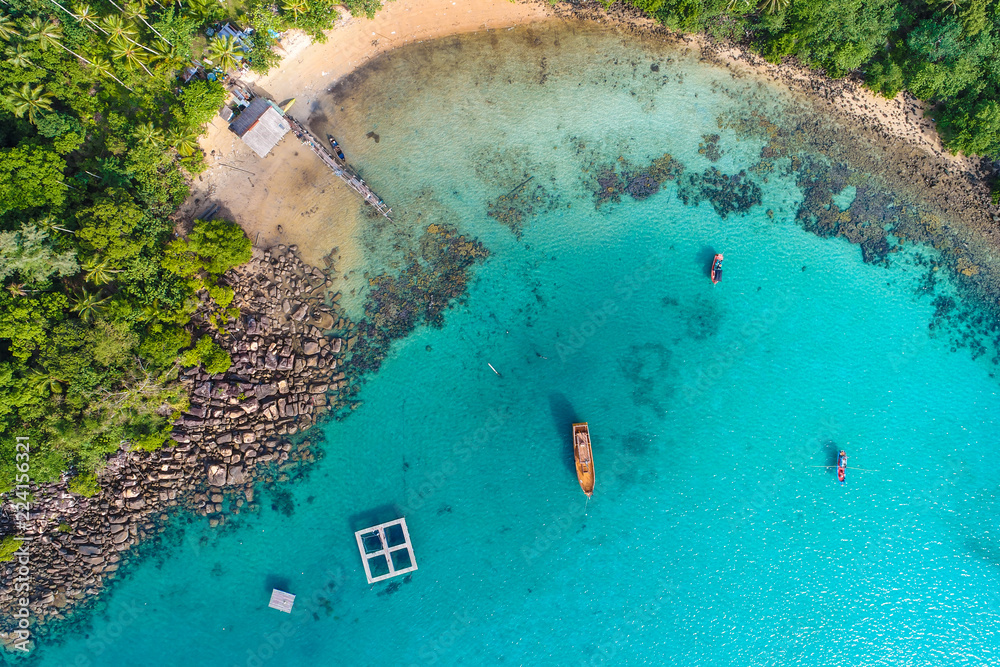 Aerial view of exotic turquoise sea with white beach green tree island