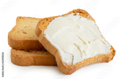 Melba toast with cream cheese lying on two plain toasts isolated on white.