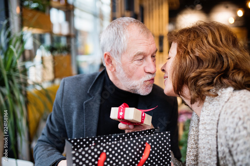 Senior couple with present doing Christmas shopping.