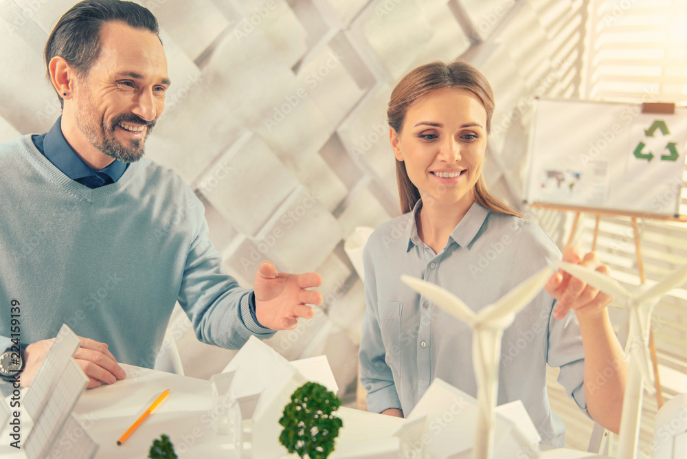 Eco energy. Joyful male person looking forward while pointing at producers of electricity Eco energy. Joyful male person looking forward while pointing at producers of electricity
