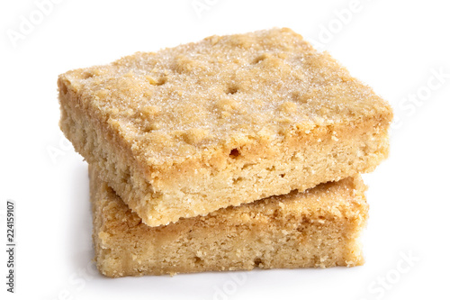 Two classic homemade square shortbread biscuits stacked and isolated on white.