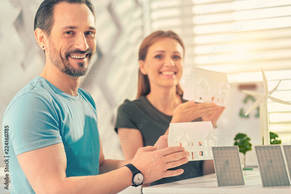 You are welcome. Pleased woman keeping smile on her face while posing on camera