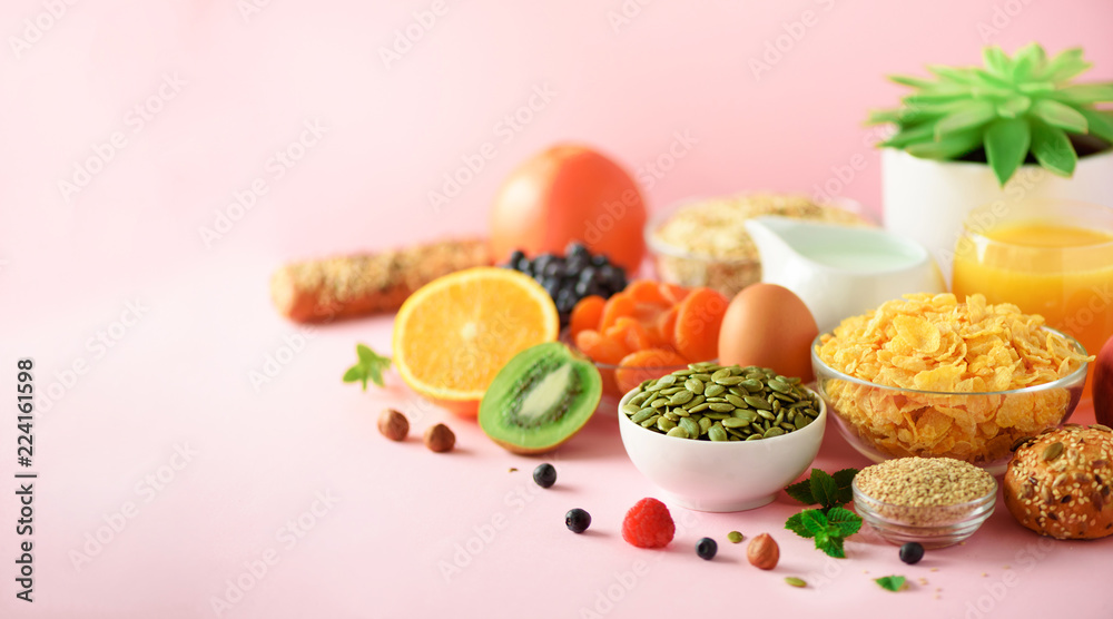 Vegetarian breakfast. Soft boiled egg, oat flakes, nuts, fruits, berries, milk, yogurt, orange, banana, peach on pink background. Healthy food diet. Copy space. Banner Vegetarian breakfast. Soft boiled egg, oat flakes, nuts, fruits, berries, milk, yogurt, orange, banana, peach on pink background. Healthy food diet. Copy space. Banner