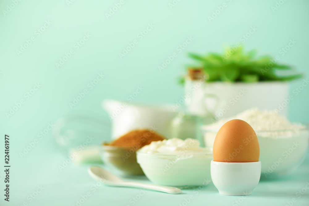 White cooking utensils on blue background. Food ingredients. Macro of egg. Cooking cakes and baking bread concept. Copy space. White cooking utensils on blue background. Food ingredients. Macro of egg. Cooking cakes and baking bread concept. Copy space.
