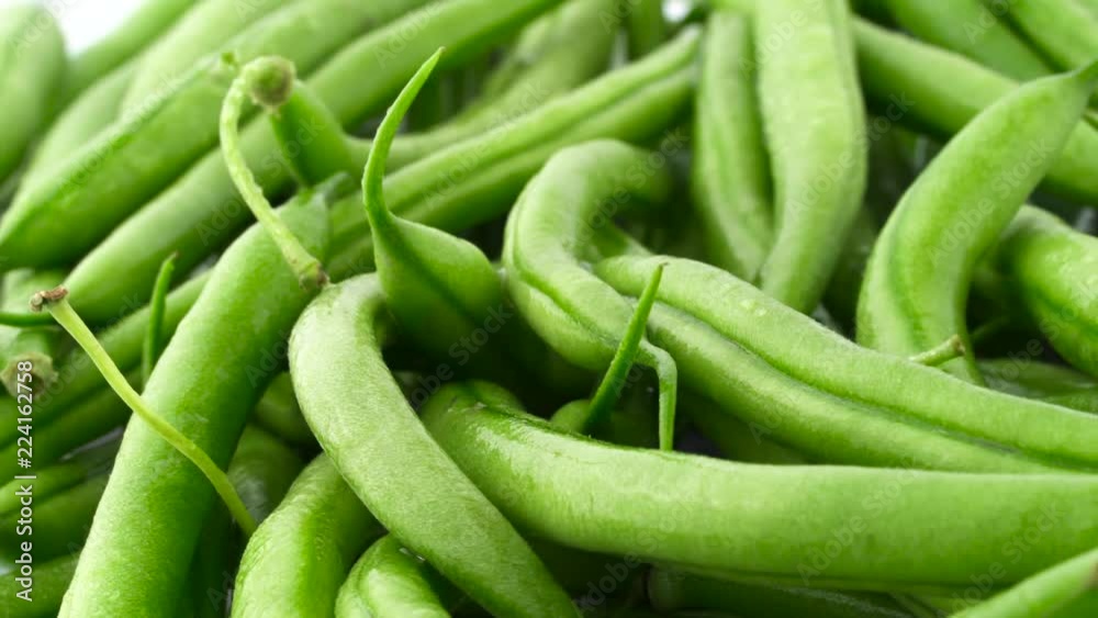Pile of fresh green beans. Rotating on the turntable. Isolated on the white color background. Pile of fresh green beans. Rotating on the turntable. Isolated on the white color background.