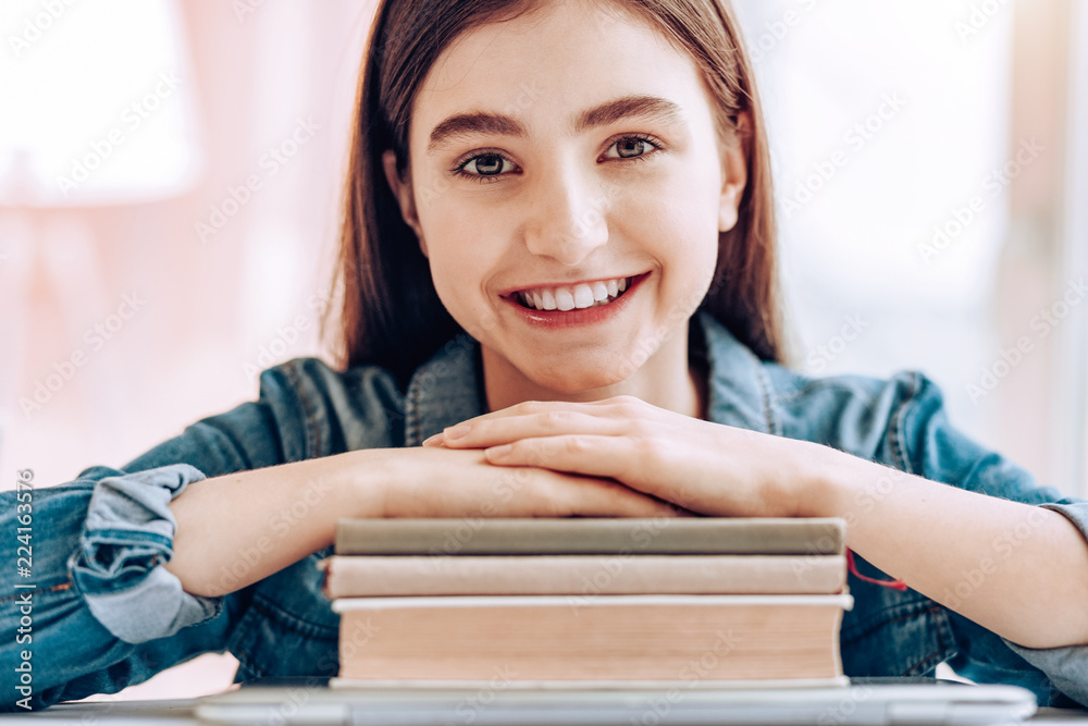 Joyful mood. Cheerful little female looking forward and having rest after studying Joyful mood. Cheerful little female looking forward and having rest after studying