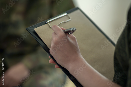 Close-up on therapist making notes on piece of paper during appointment