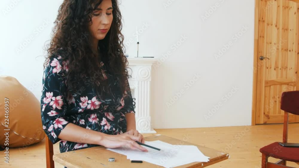 Young attractive woman inspiredly drawing on paper Young attractive woman inspiredly drawing on paper