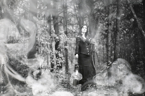 Woman in a witch suit in a dense forest