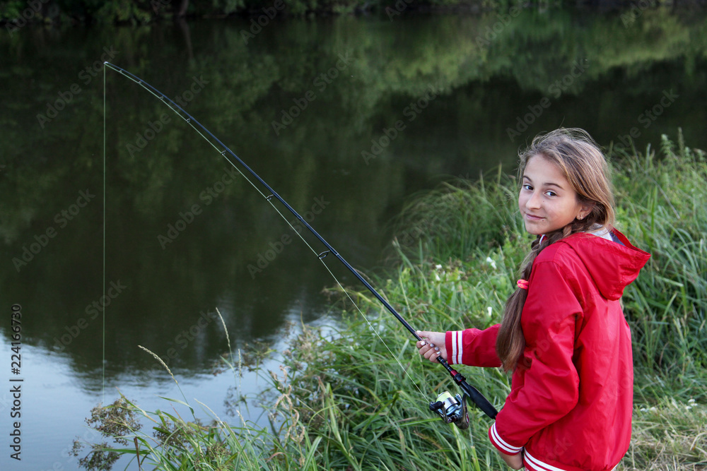Pretty teen girl fishing on the river. Summer vacation Pretty teen girl fishing on the river. Summer vacation