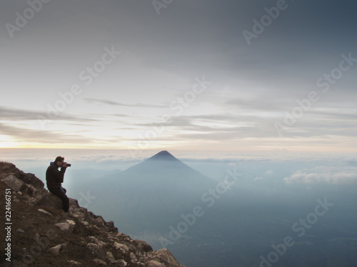 Photographer overlooking the volcanic landscape of Guatemala during sunrise