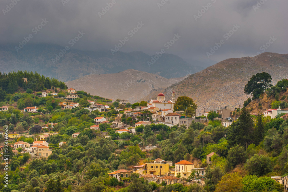 dramatic view landscape, mountain village on the slopes in Greece under the approaching thunderstorm