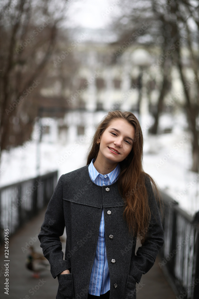 Young girl outdoors in winter. Model girl posing outdoors