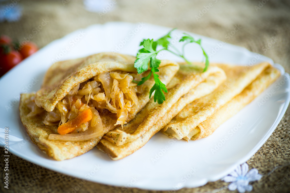 thin fried pancakes stuffed with stewed cabbage in a plate thin fried pancakes stuffed with stewed cabbage in a plate