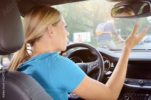 Foto Woman as a motorist is in dispute with a cyclist and scolds of annoyance during