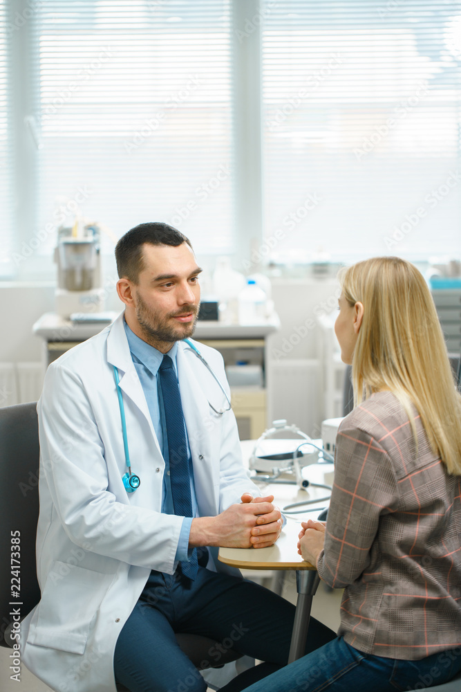 In Medical Office Friendly Doctor Talks with a Beautiful Blonde Woman. Health Care Professional Consultation in the Bright Modern Office.