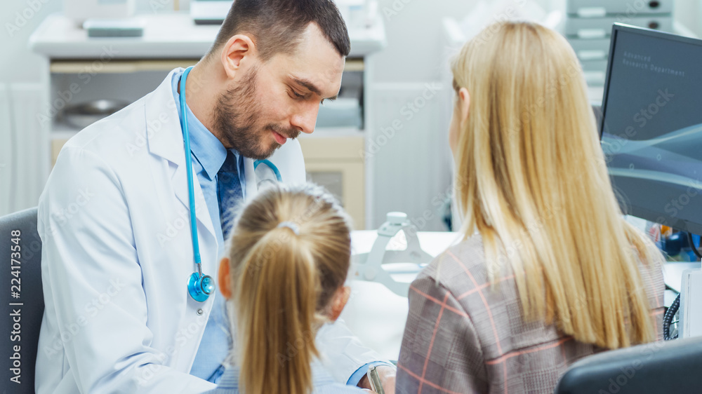 Fototapeta premium Mother with Her Cute Little Girl Have Doctor's Appointment. Friendly Pediatrician Smiles and Writes Prescription from the Illness. Modern and Bright Medical Doctor's Office.