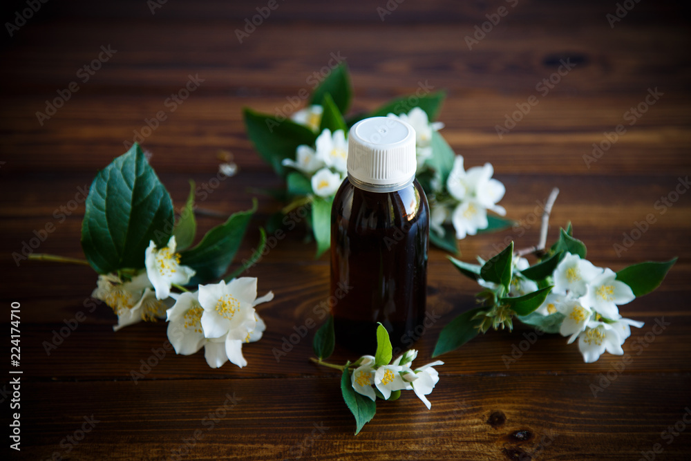 Essential aroma oil with jasmine on wooden Essential aroma oil with jasmine on wooden