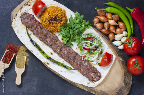 turkish adana kebab with vegetables on the plate photo