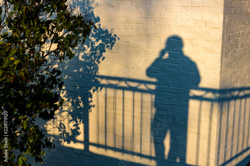 The shadow of a man on a white building wall 