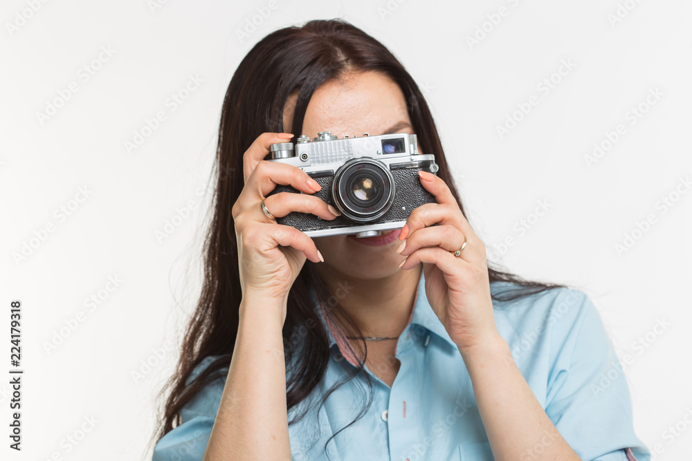 Photographer, hobby and people concept - Young brunette woman with retro camera on white background Photographer, hobby and people concept - Young brunette woman with retro camera on white background