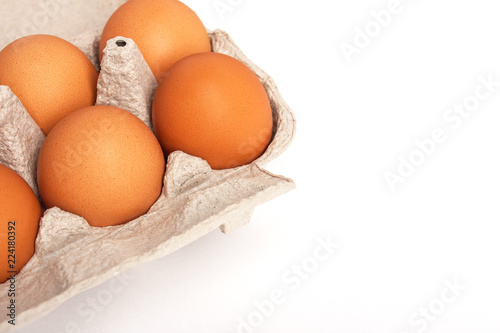 Eggs lies in a cardboard gray box on a white (isolated) background with copy space