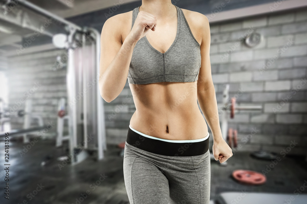 Slim young woman body in gym interior and free space for your decoration. 