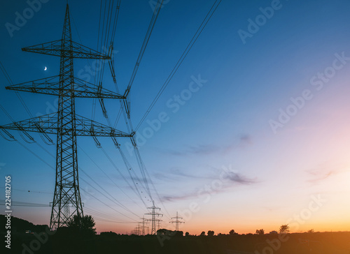 electricity pylons at sunset transporting clean renewable energy