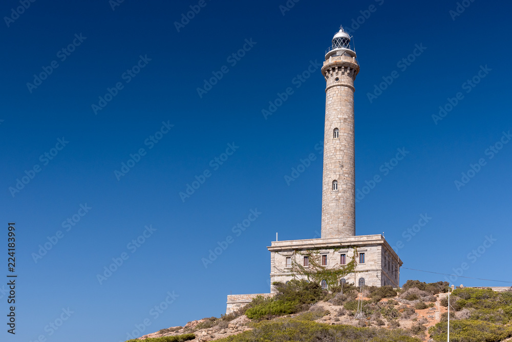 Lighthouse of Cabo de Palos, cape in the Spanish municipality of Cartagena, in the region of Murcia. It is summer, and the sky is a deep blue