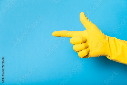 Hand in clean yellow glove, bathroom. Copy space for text. photo