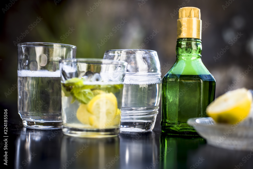 Mojito drink in a transparent glass on wooden surface with white rum,soda,lemon juice,fresh mint leaves,ice cubes and sugar,Close up shot or top shot. Mojito drink in a transparent glass on wooden surface with white rum,soda,lemon juice,fresh mint leaves,ice cubes and sugar,Close up shot or top shot.
