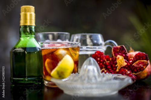 Pamosa or pomosa drink or classic mimosa drink in a transparent glass with champagne,pomegranate juice or annar ka juice,lemon juice,mint leaves,ice cubes and raw pomegranate and lemon,Close up view,