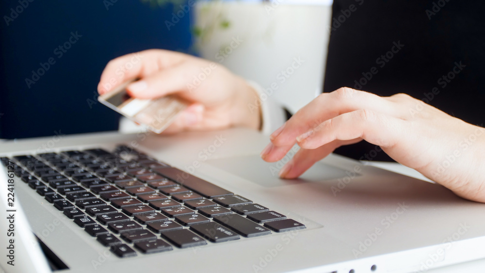 Closeup photo of young woman making online purchases and paying with credit card Closeup photo of young woman making online purchases and paying with credit card