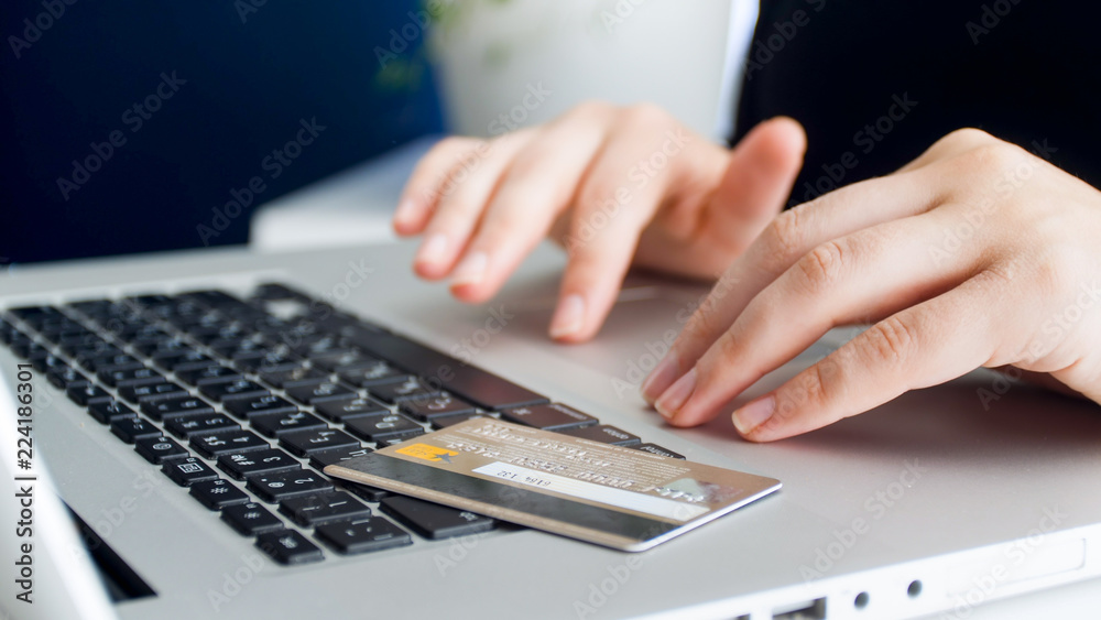Closeup image of woman doing online shopping and using credit card Closeup image of woman doing online shopping and using credit card