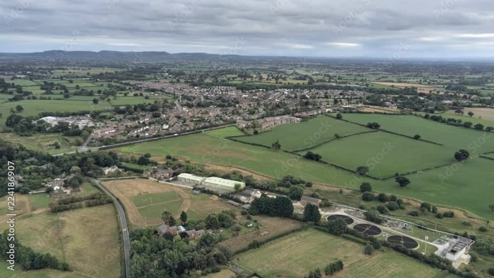 Aerial view, zoom in move. Sewage works, Tarvin residential area houses among fields on Cheshire countryside. Aerial view, zoom in move. Sewage works, Tarvin residential area houses among fields on Cheshire countryside.