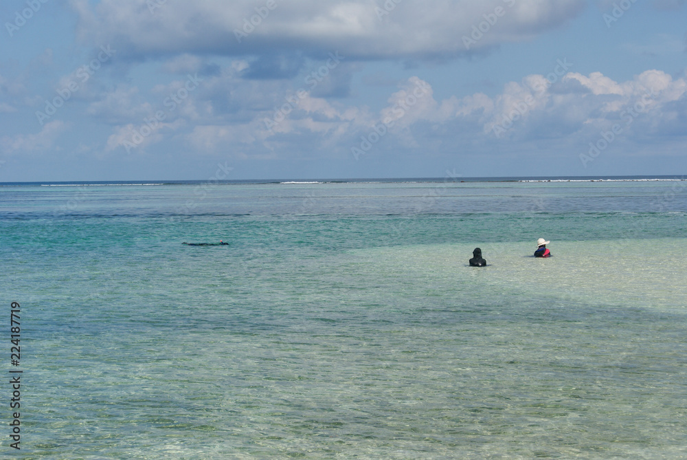 Local people from Maldives islands swimming on an amazing beach