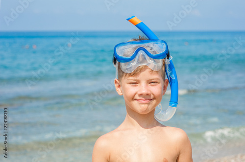 Smiling little boy in snorkeling mask at beach. Space for text