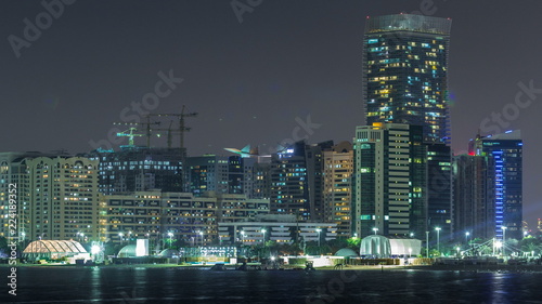 Panorama view of Abu Dhabi Skyline and seafront at night timelapse  United Arab Emirates
