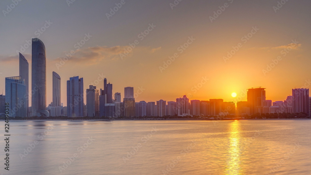 Abu Dhabi city skyline on sunrise time with water reflection timelapse.