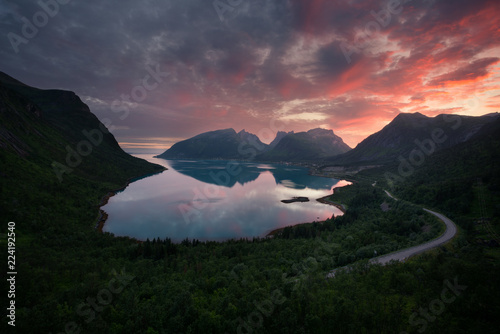 Beautiful vibrant sunset behind fjord mountains in Bergsbotn, Senja, Norway photo